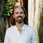 Venture Investing Meets Conscious Capital with Christopher Mackin Investor in white linen shirt by a tree—regenerative approach to venture and conscious capital.