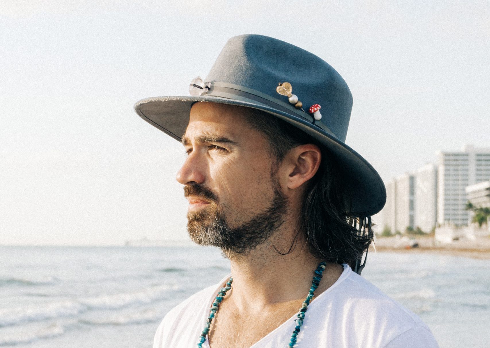 Side-profile beach portrait of a mindful venture investor—conscious capital leadership and purpose-driven focus.